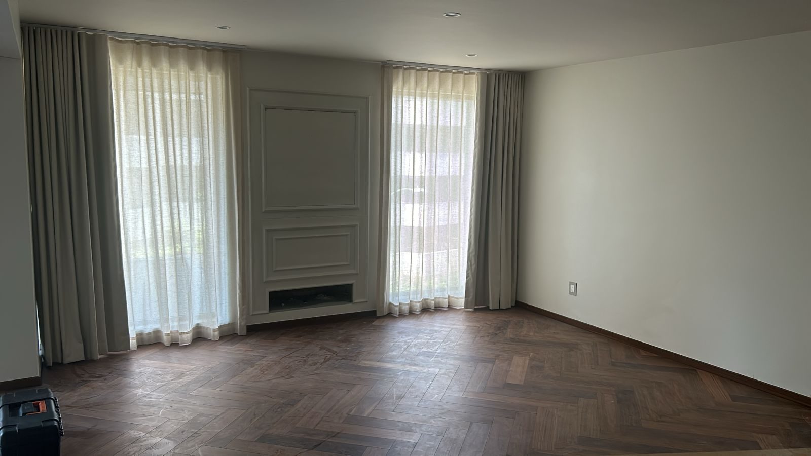Cortinas translucidas con acabado en madera y piso de duela en espiga